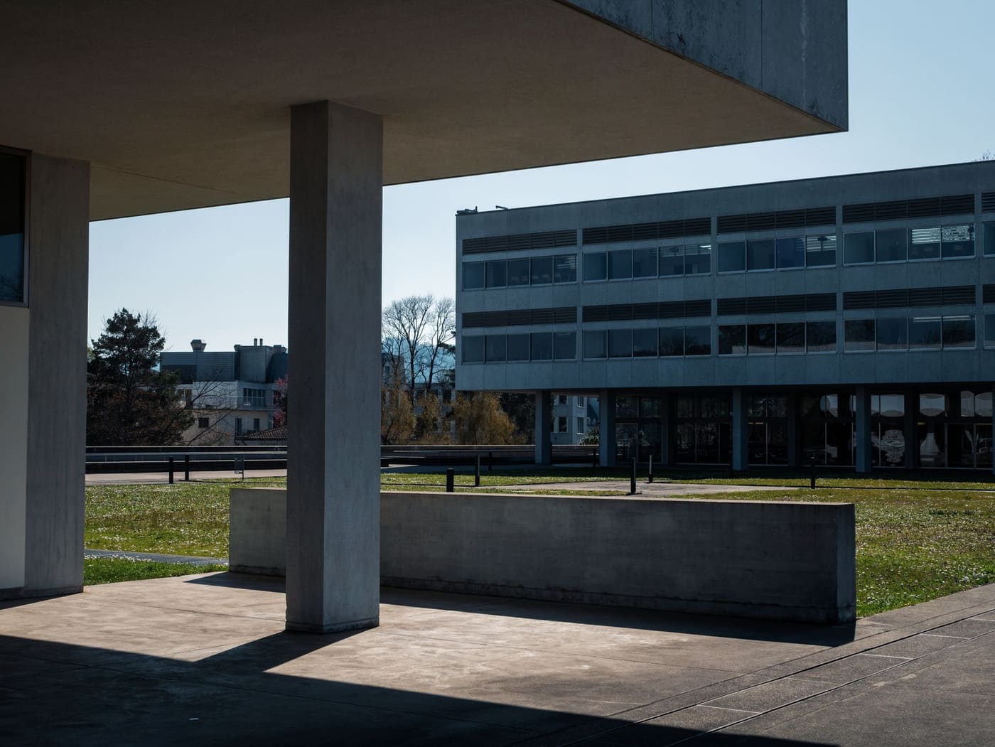 Concrete university buildings around a grassy courtyard on a clear day