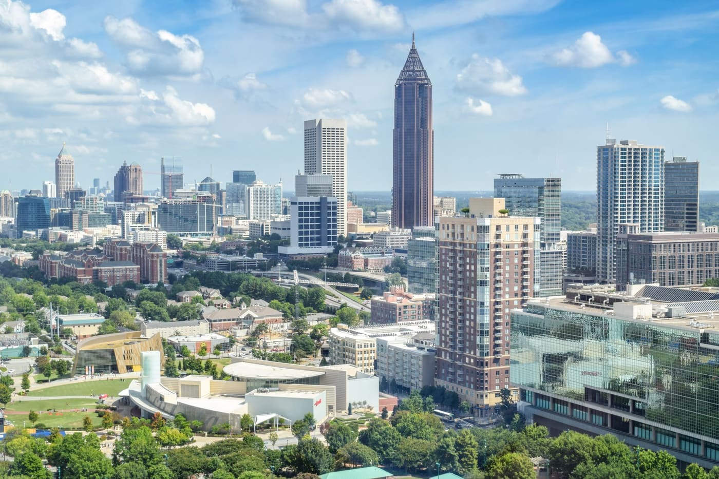 Aerial view of downtown and Midtown Atlanta high-rises on a sunny day, with green parkland in the foreground