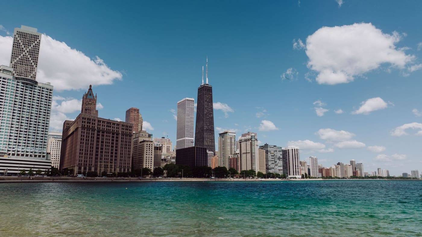 Chicago's Gold Coast high-rises and the tapered dark tower of 875 North Michigan Avenue rising above the turquoise water of Lake Michigan