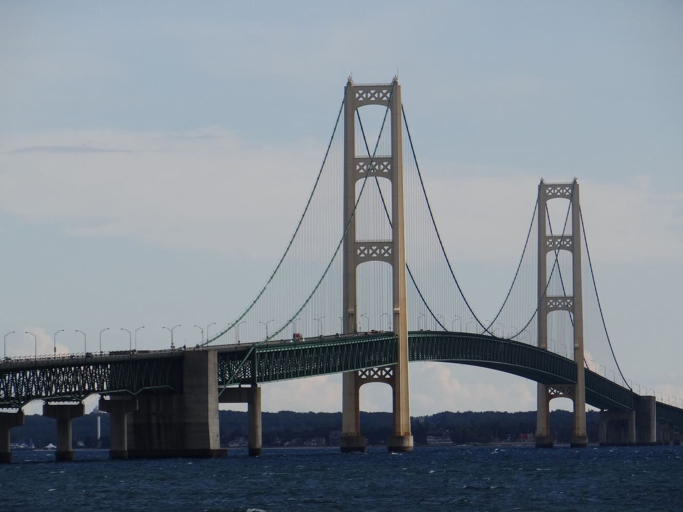 The Mackinac Bridge's two towers and suspension cables over the dark blue water of the Straits of Mackinac