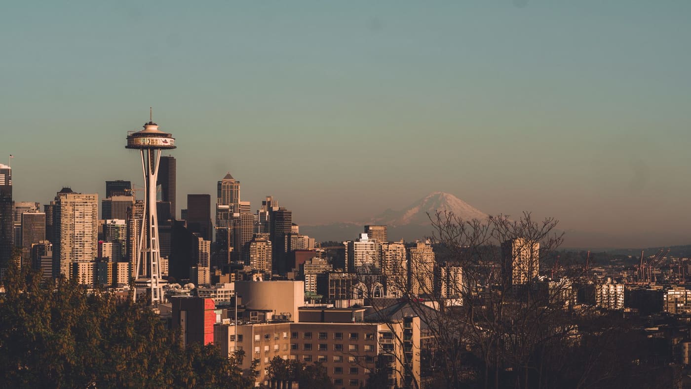 Seattle's skyline and the Space Needle at sunset with snow-capped Mount Rainier on the horizon