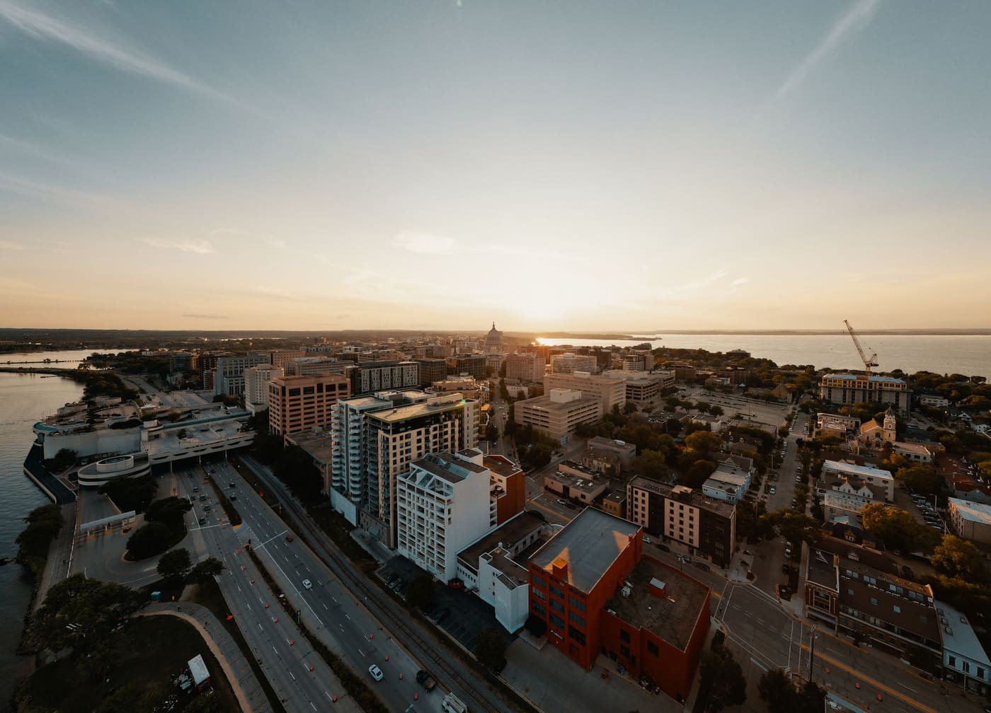 Aerial view of downtown Madison at sunset, with the State Capitol dome between Lake Monona and Lake Mendota